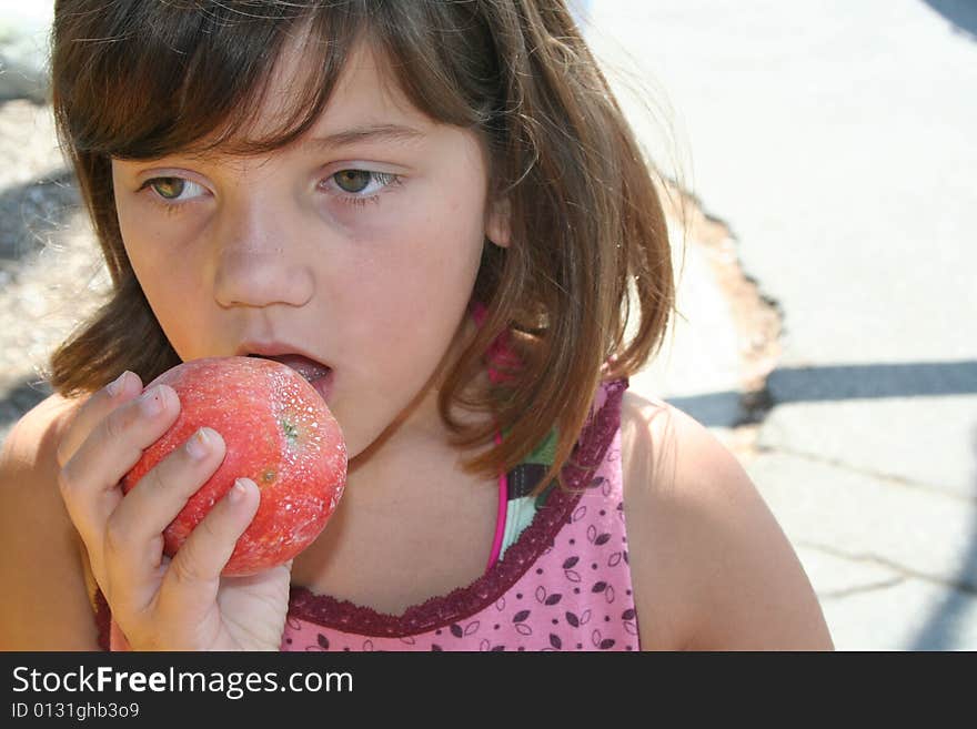 Young girl biting into an apple. Young girl biting into an apple.