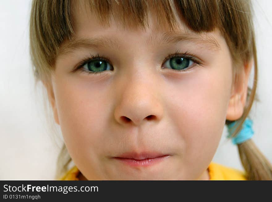 A little beautiful child (girl) gives a look 
Child's head on white background. A little beautiful child (girl) gives a look 
Child's head on white background.