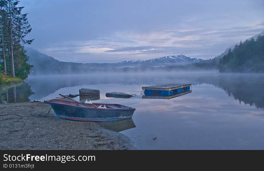 Boat on the shore of the mountain lake in early morning. Boat on the shore of the mountain lake in early morning