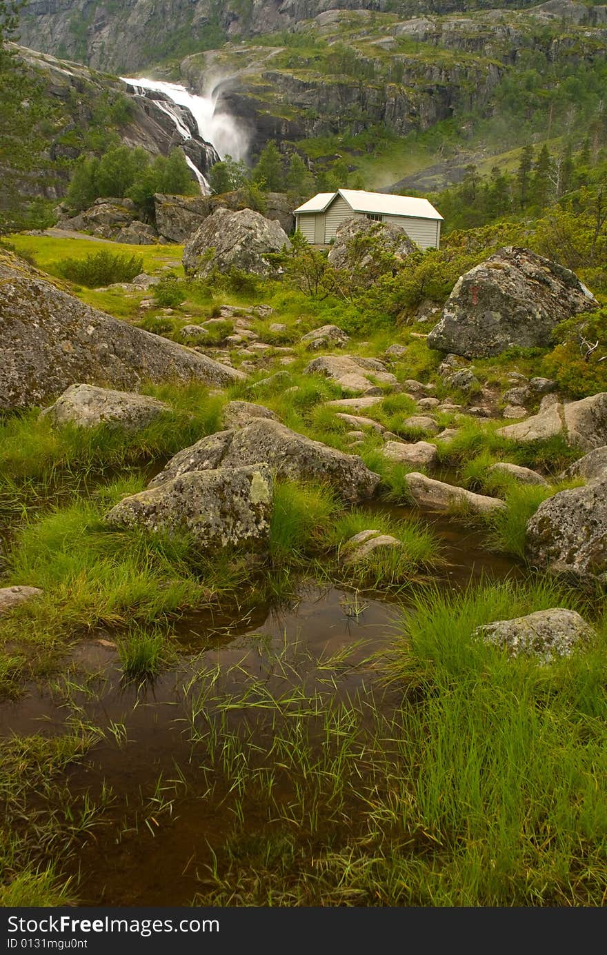 Waterfall and mountain cabin