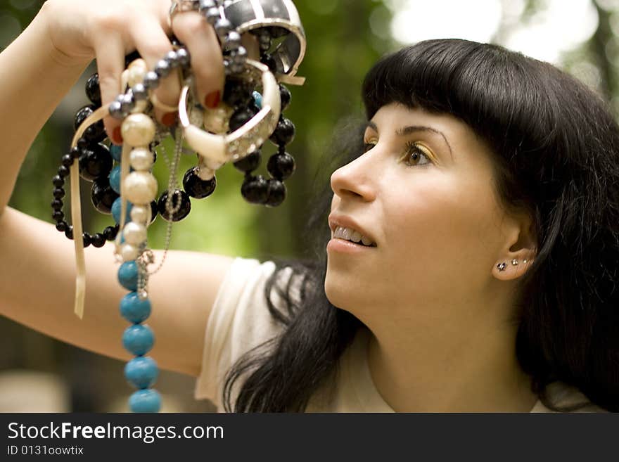 Closeup portrait on young brunette holding a lot of beads