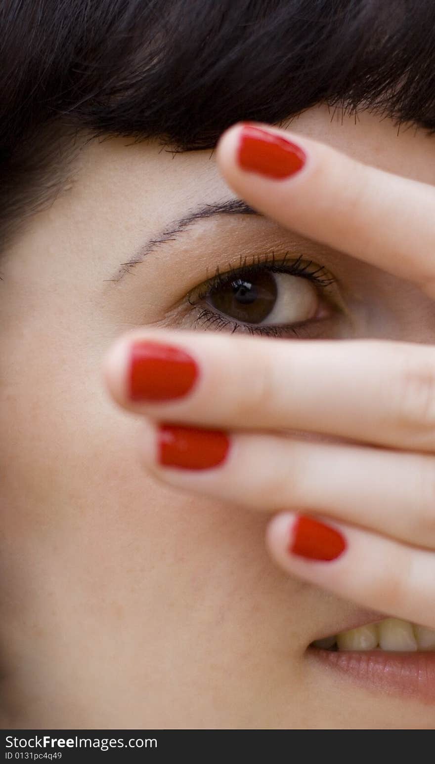 Pretty brunet girl covering her face, looking through fingers