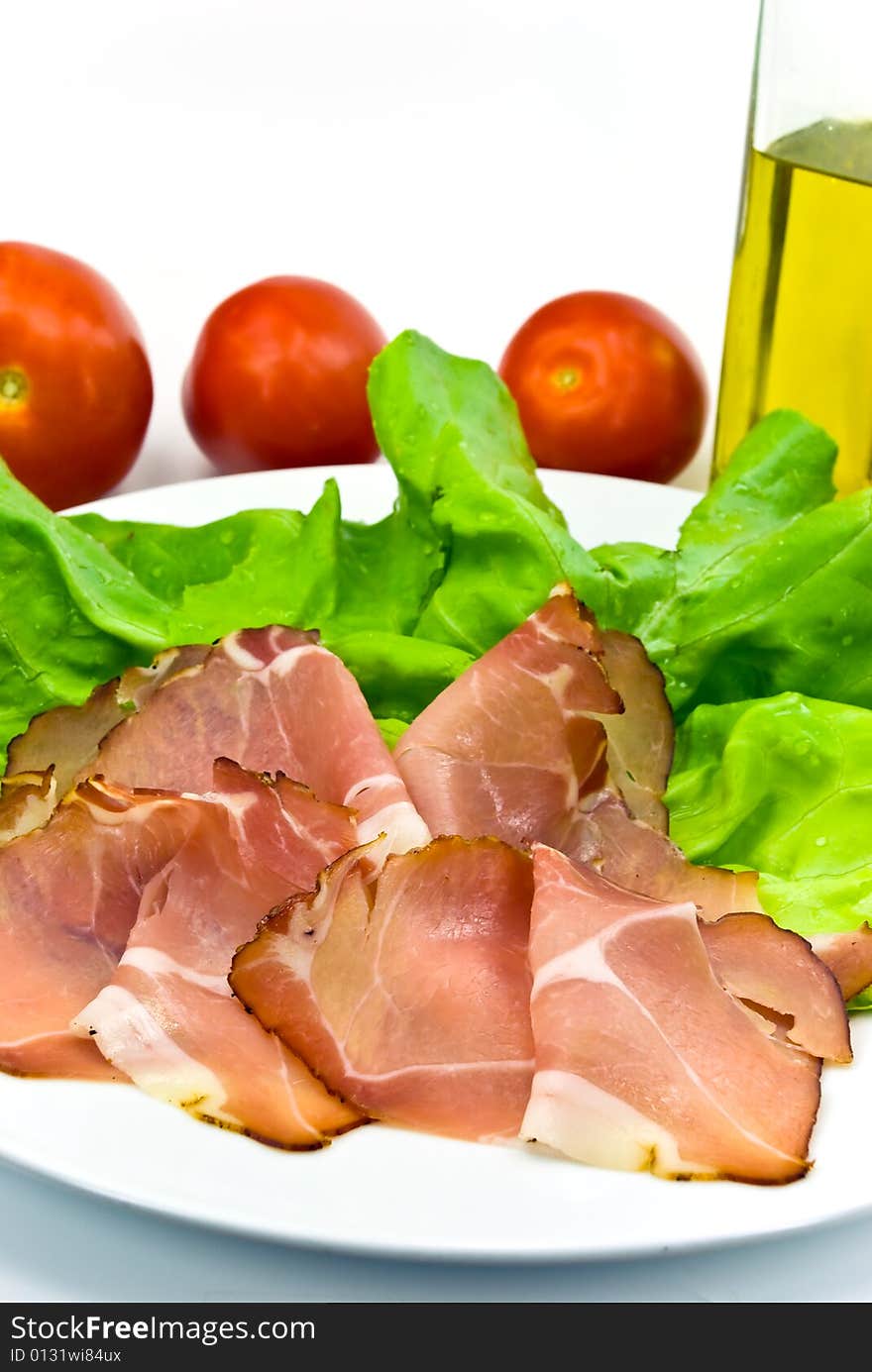 Many smoked slices of ham with salad