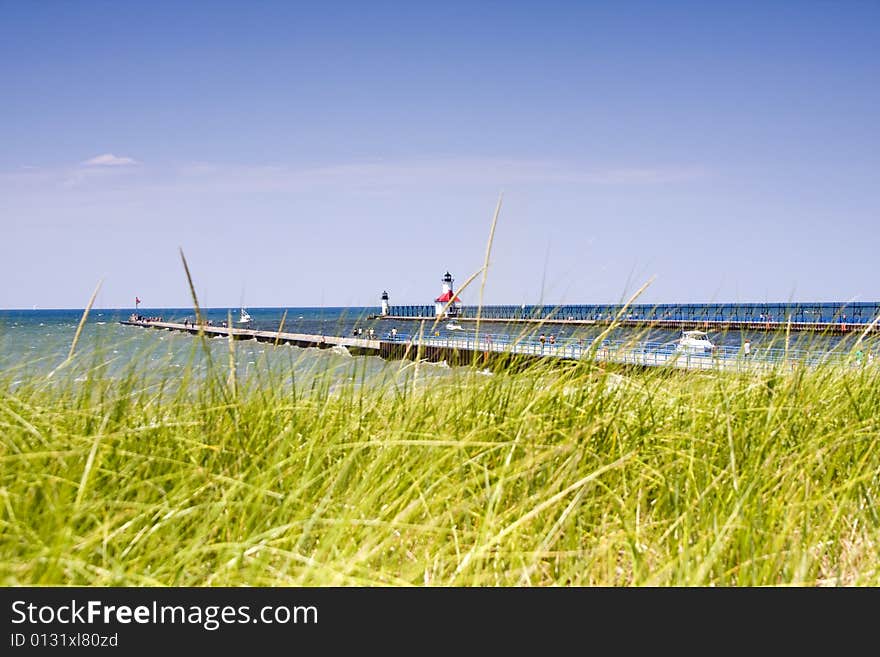 Piers at the harbor entrance to St. Joseph, Michigan, with out of focus dune grass in foreground. Piers at the harbor entrance to St. Joseph, Michigan, with out of focus dune grass in foreground.