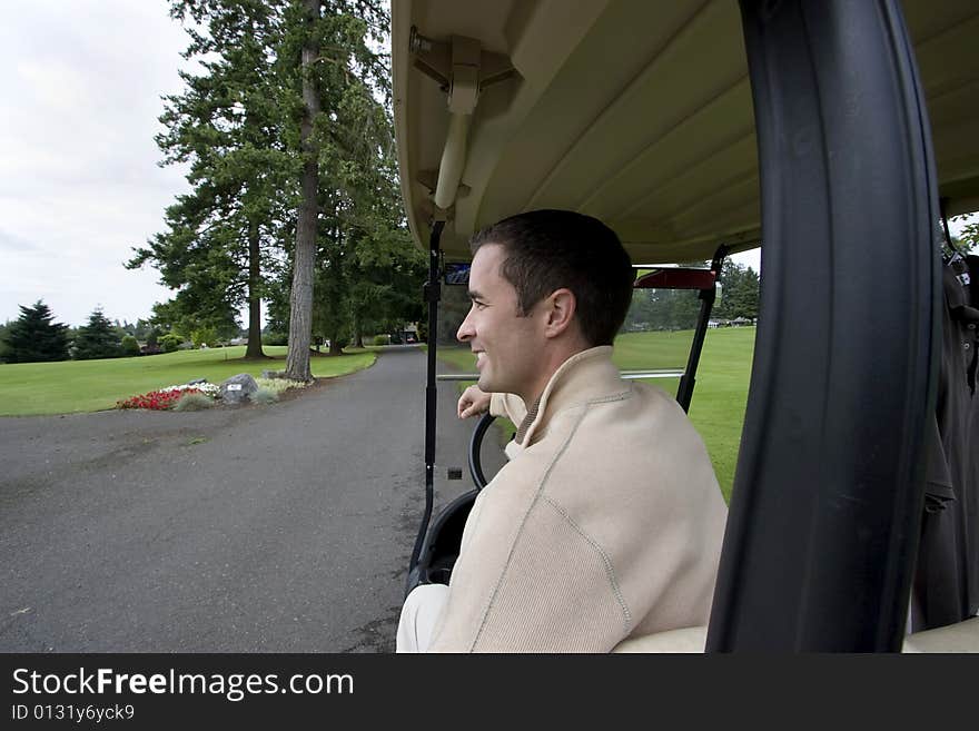 Man smiling as he sits in golf cart. Horizontally framed photo. Man smiling as he sits in golf cart. Horizontally framed photo.