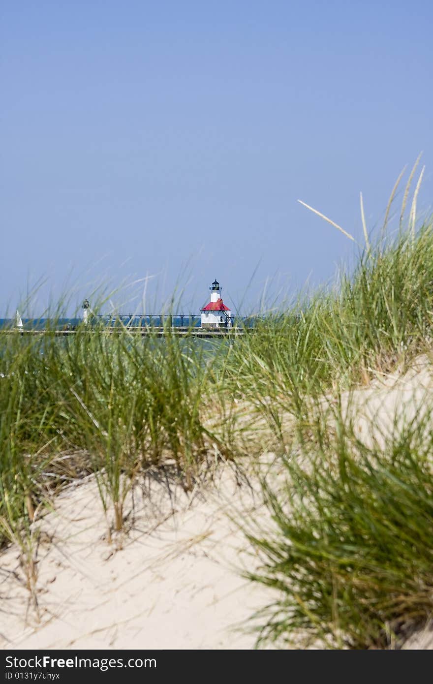 Sand dunes with lighthouse on the piers at St. Joseph, Michigan, in the background. Sand dunes with lighthouse on the piers at St. Joseph, Michigan, in the background.