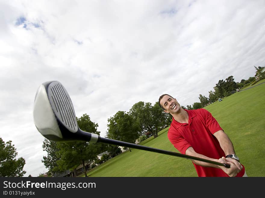 Man holding golf club away from him while he laughs. Horizontally framed photo. Man holding golf club away from him while he laughs. Horizontally framed photo.