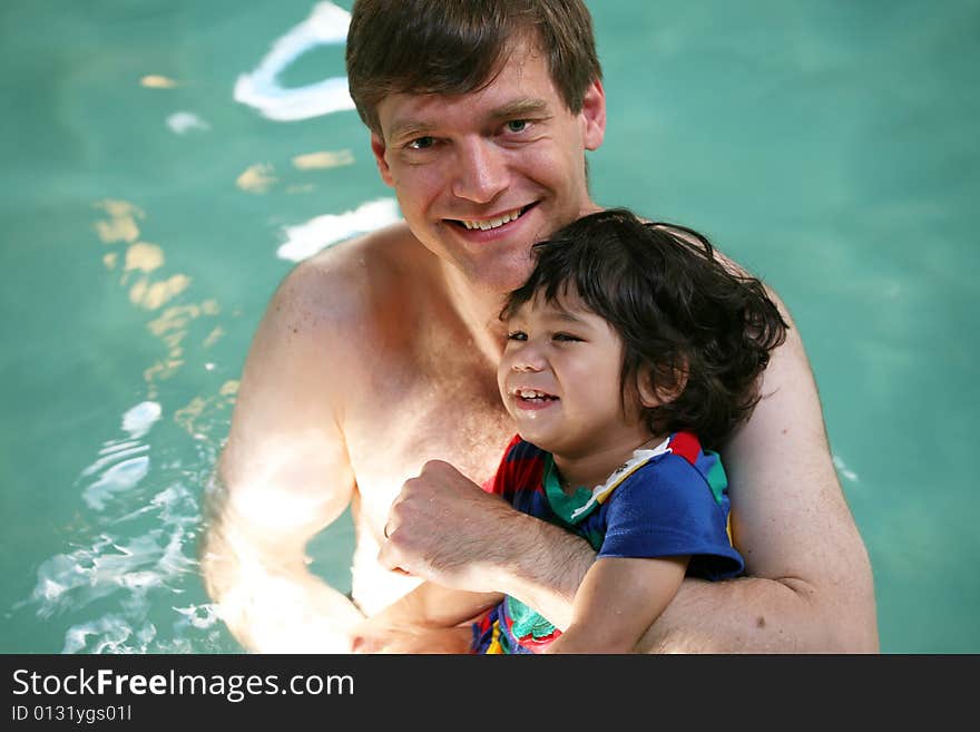 Father swimming with toddler in pool. Father swimming with toddler in pool