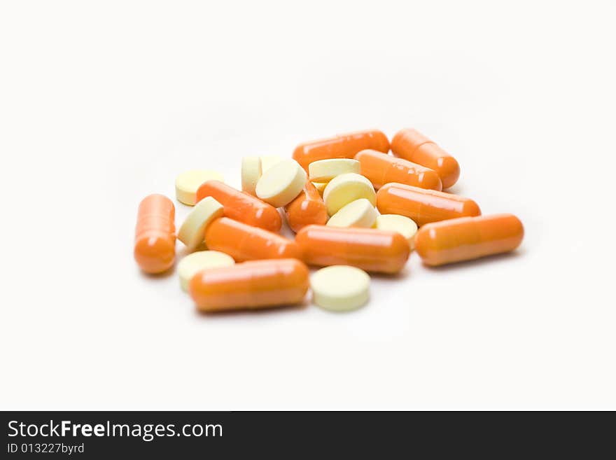 A few orange pills, isolated over white background. A few orange pills, isolated over white background