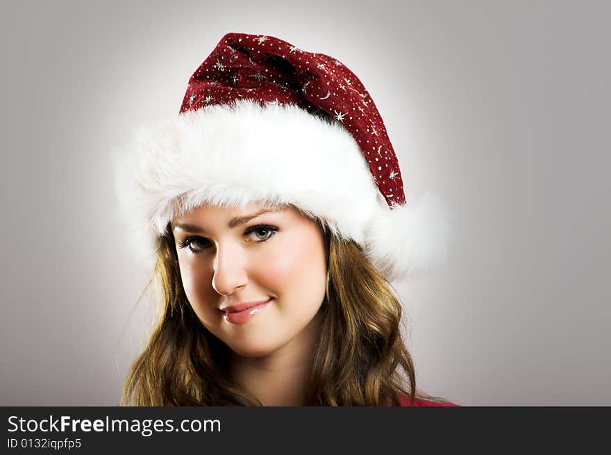 Winter portrait of a beautiful young smiling woman with a christmas cap. Winter portrait of a beautiful young smiling woman with a christmas cap