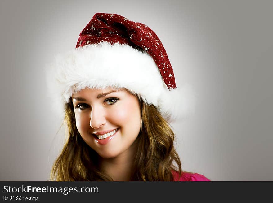 Winter portrait of a beautiful young smiling woman with a christmas cap. Winter portrait of a beautiful young smiling woman with a christmas cap