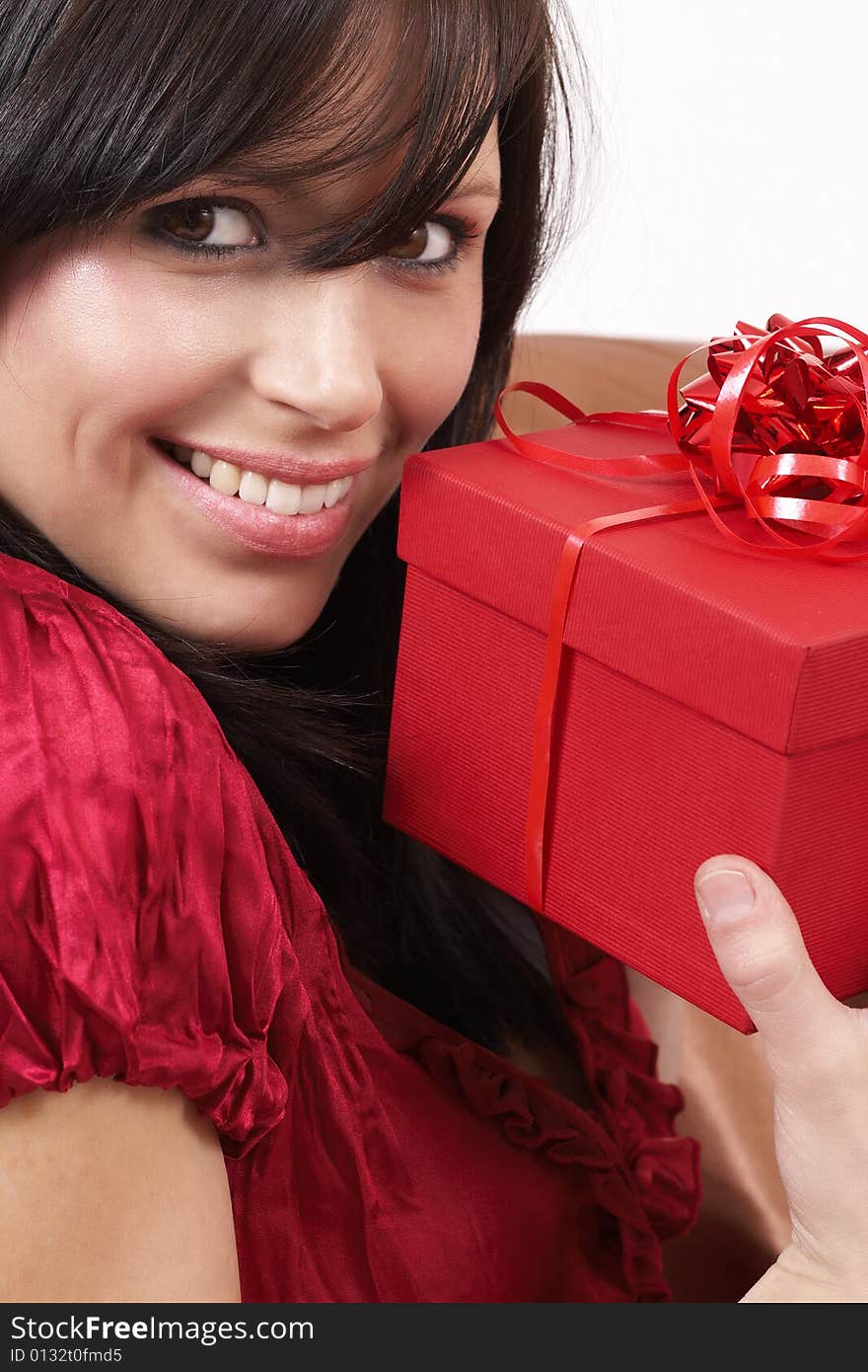 Portrait of a beautiful young brunette woman holding gift box at a celebration. Portrait of a beautiful young brunette woman holding gift box at a celebration