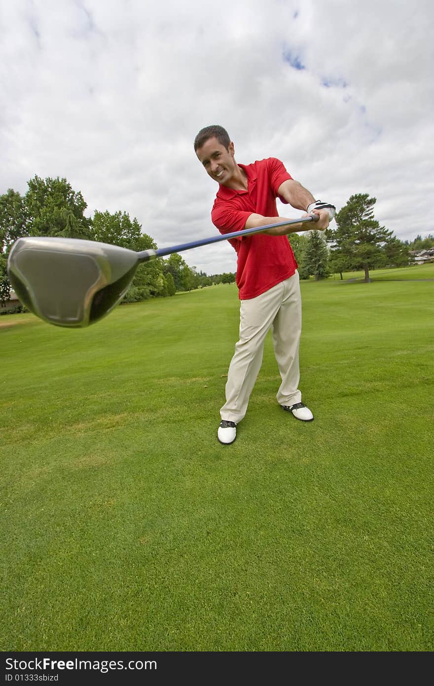 Man holding golf club far away from him and smiling. Vertically framed photo. Man holding golf club far away from him and smiling. Vertically framed photo.