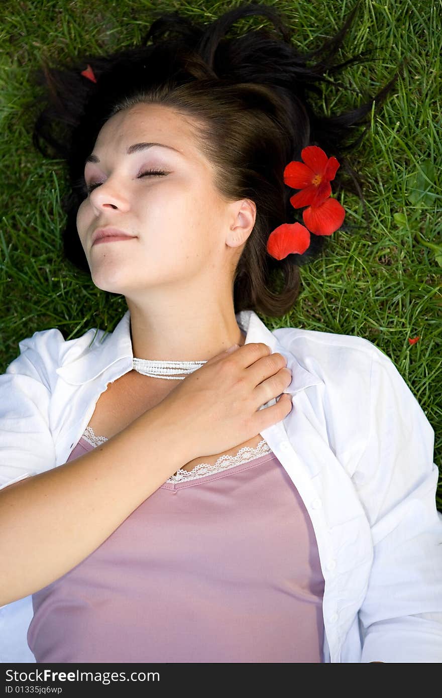 Attractive brunette woman lying on grass. Attractive brunette woman lying on grass