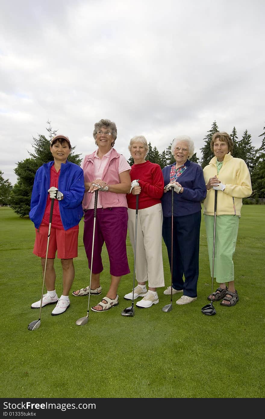 Five smiling, elderly women carrying golf clubs. Vertically framed photo. Five smiling, elderly women carrying golf clubs. Vertically framed photo.