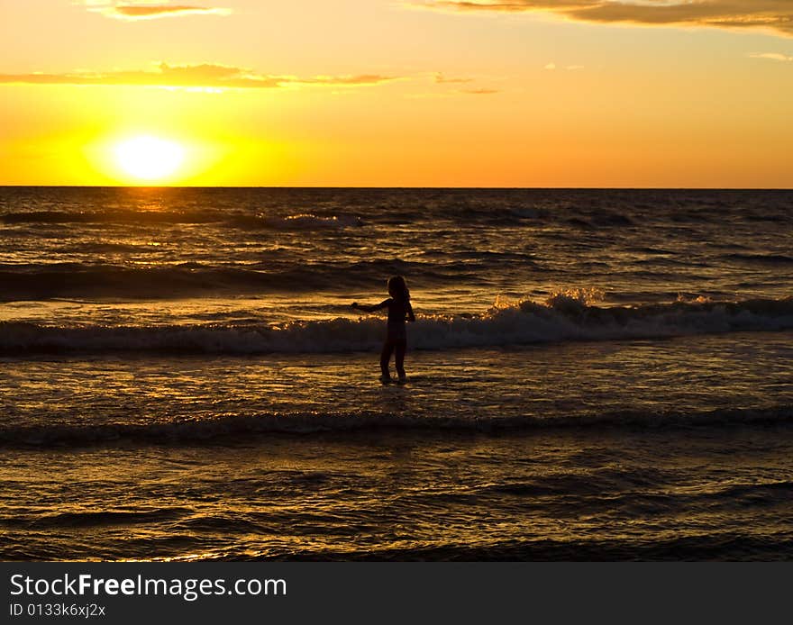 Child in the sea while sun falling. Child in the sea while sun falling