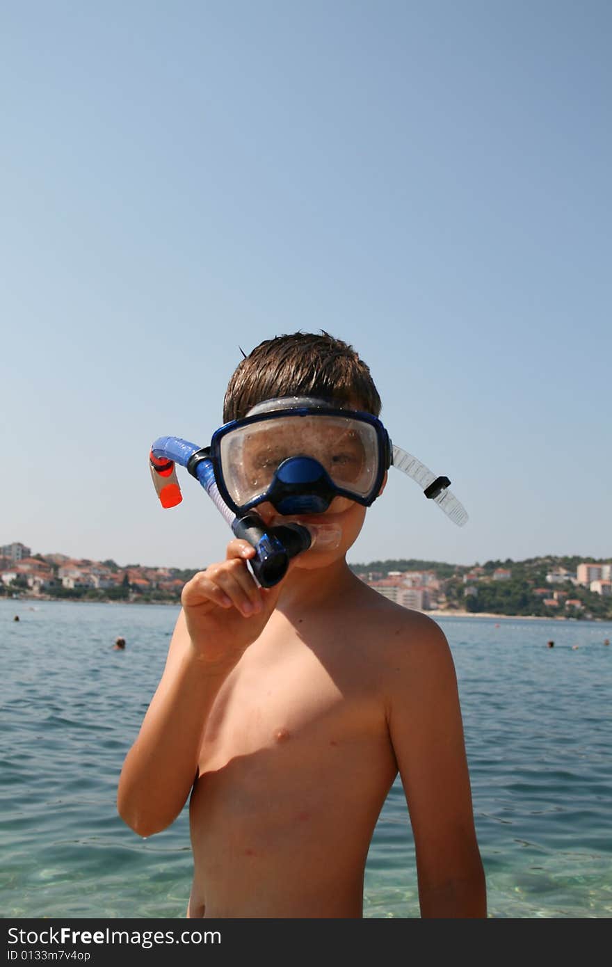 Boy on a beach ready to swim. Boy on a beach ready to swim