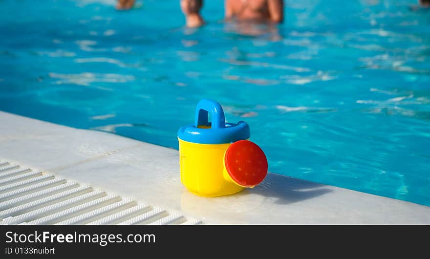 Cute child s watering-can at the pool