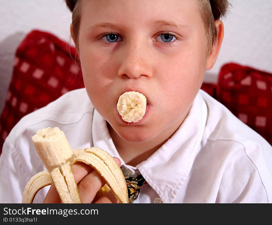 A young boy is eating a banana