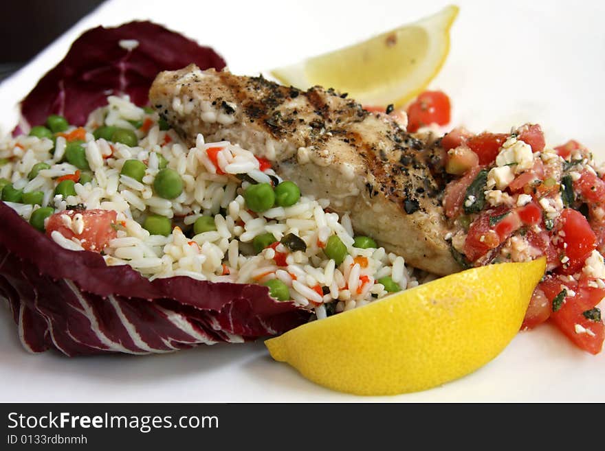 Grilled salmon with lemon and rice on red cabbage leaf