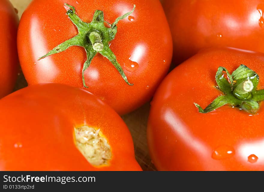 Several fresh tomatoes on wooden desk