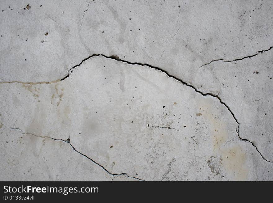 Cracks on the grey wall surface