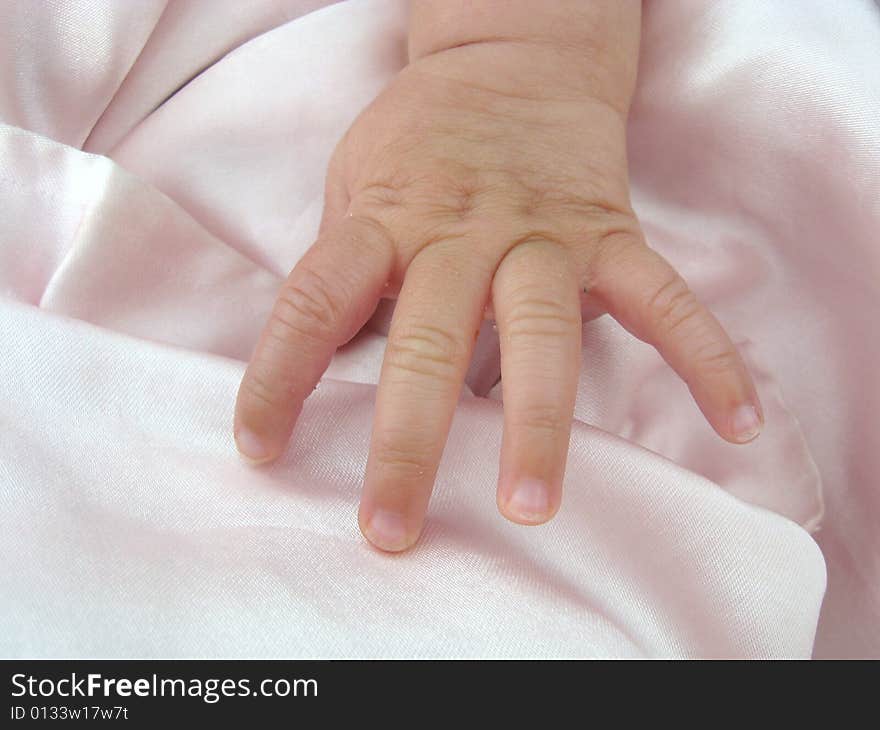 Baby girl hand on pink blanket. Baby girl hand on pink blanket