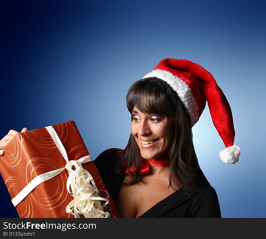 Young woman wearing santa claus hat with a present. Young woman wearing santa claus hat with a present