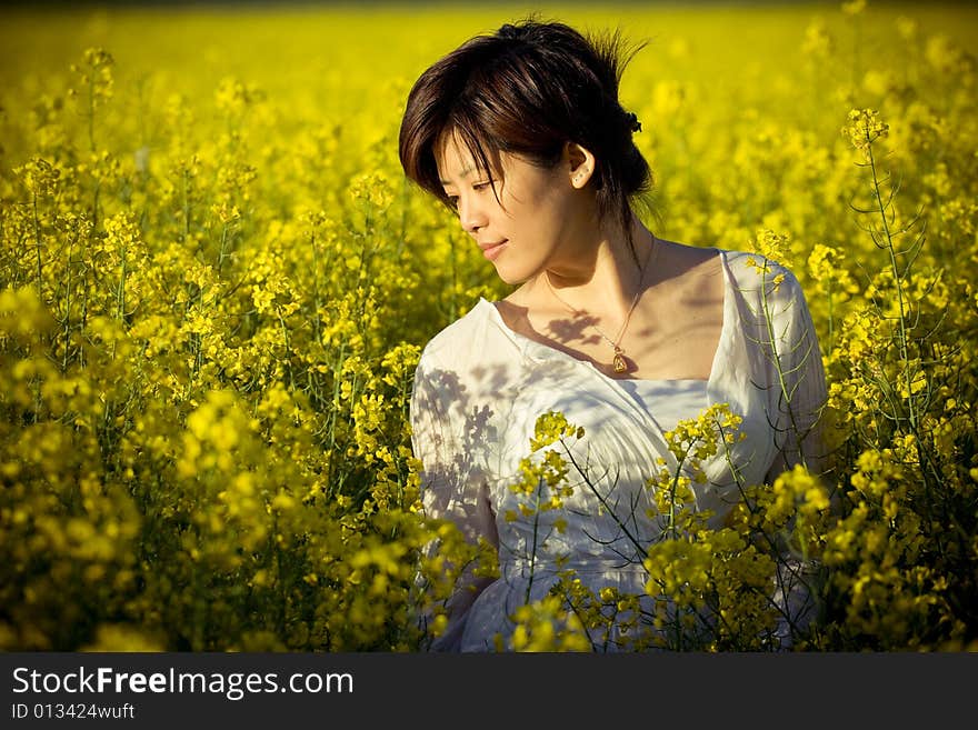 A girl in casual dress. taken in a field of rape. A girl in casual dress. taken in a field of rape.