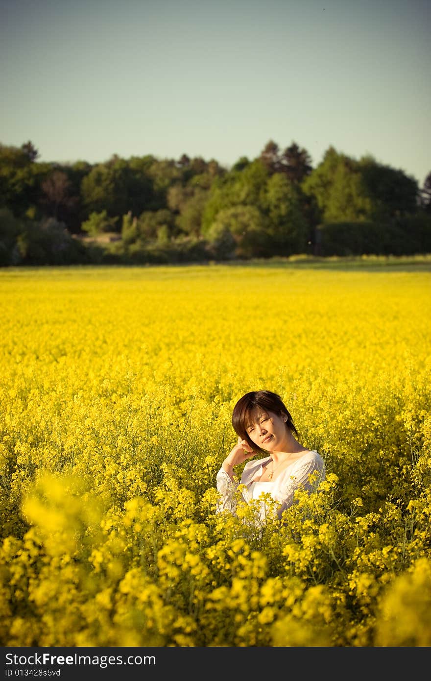 A girl in casual dress. taken in a field of rape. A girl in casual dress. taken in a field of rape.