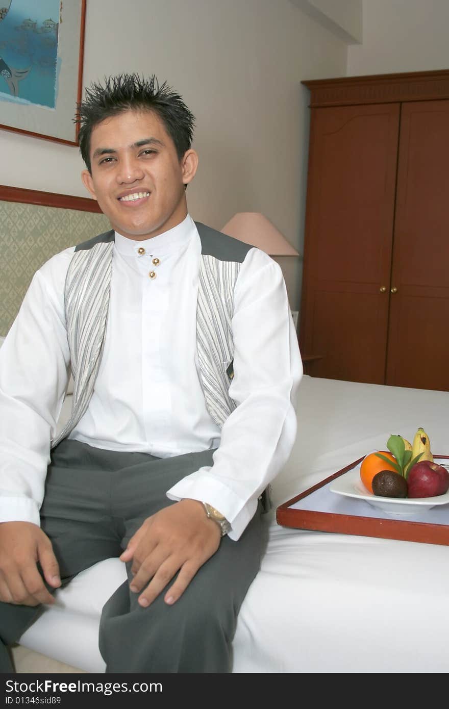 Room service waiter deliver fruit in hotel room smiling