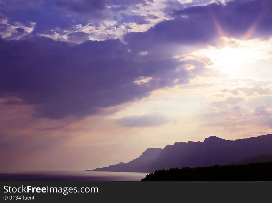 The sun came out because of the clouds. Evening on the Black Sea. Soon the sun over the mountains and hided occur overnight. The sun came out because of the clouds. Evening on the Black Sea. Soon the sun over the mountains and hided occur overnight.