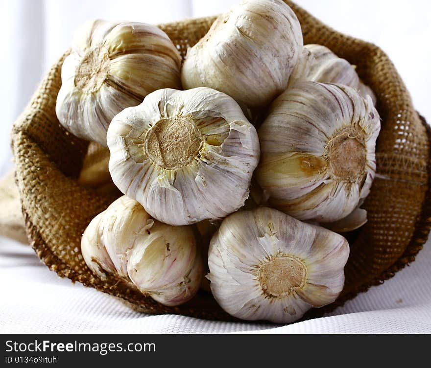 Garlic heads poking our of linen bag.