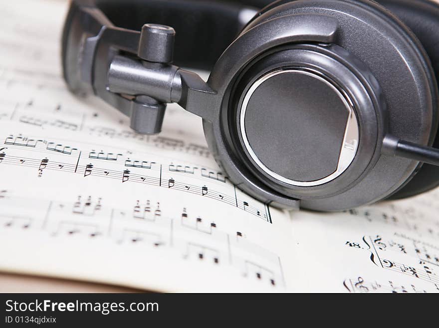 Headphone  on a book of score sheet. Headphone  on a book of score sheet