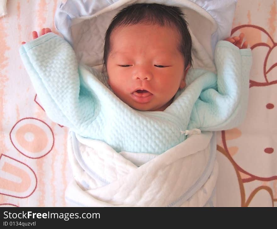 A Chinese baby on a bed. A Chinese baby on a bed