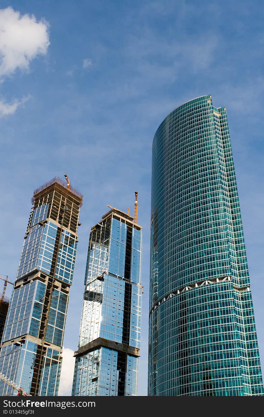 Builded skyscrapers on a background of the blue sky with clouds