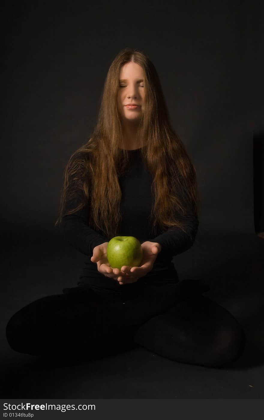 The portrait of a woman with a green apple in her hands. The portrait of a woman with a green apple in her hands