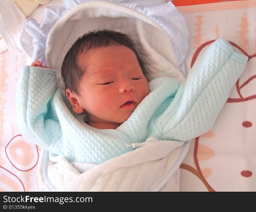 A Chinese baby on a bed. A Chinese baby on a bed