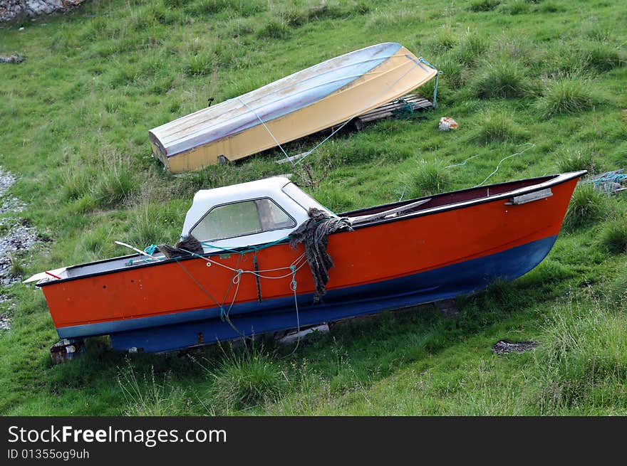 Old obsolete wooden boats on grass coast