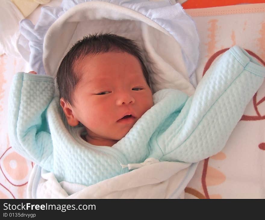 A Chinese baby on a bed. A Chinese baby on a bed