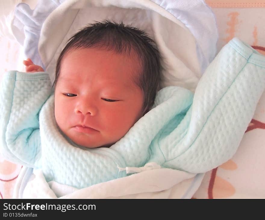 A Chinese baby on a bed. A Chinese baby on a bed