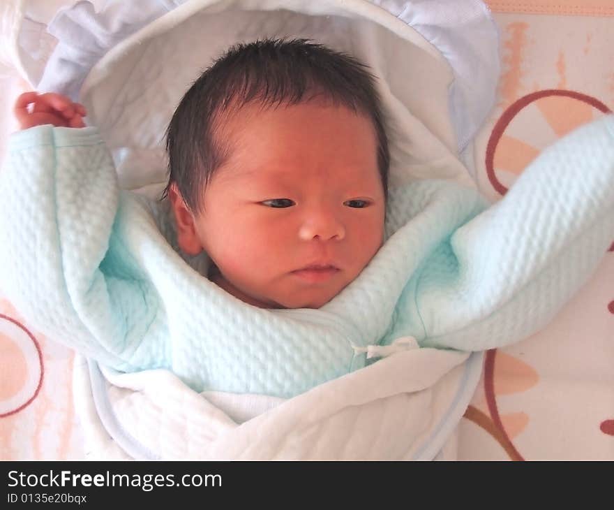 A Chinese baby on a bed. A Chinese baby on a bed