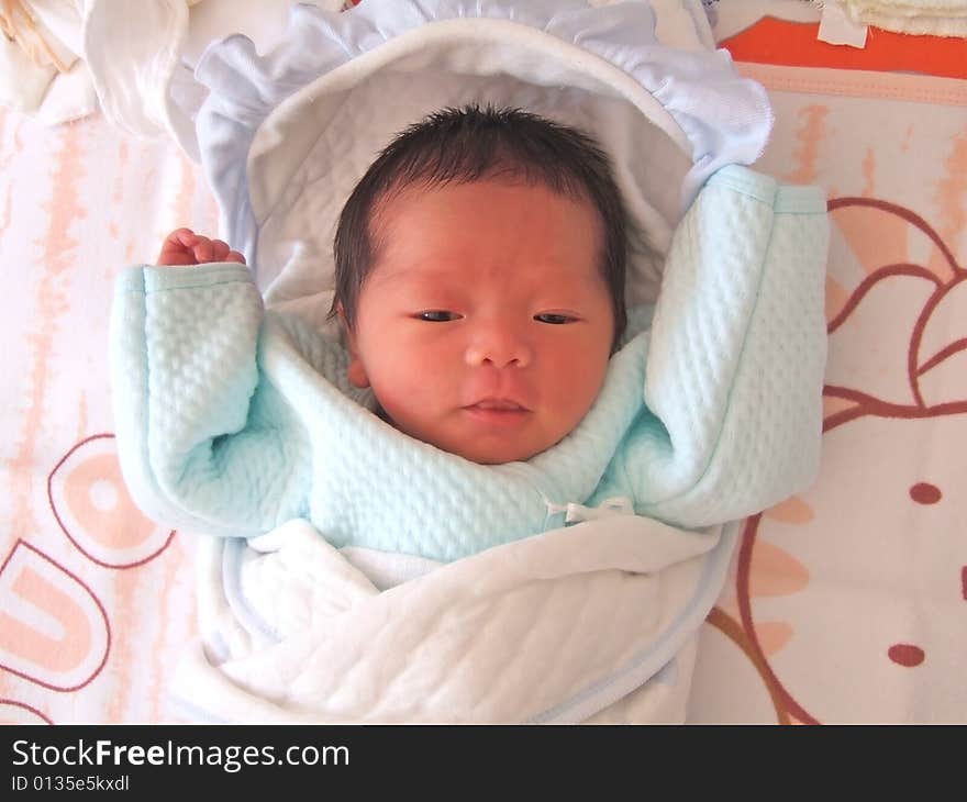 A Chinese baby on a bed. A Chinese baby on a bed