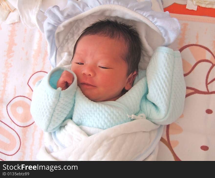 A Chinese baby on a bed. A Chinese baby on a bed