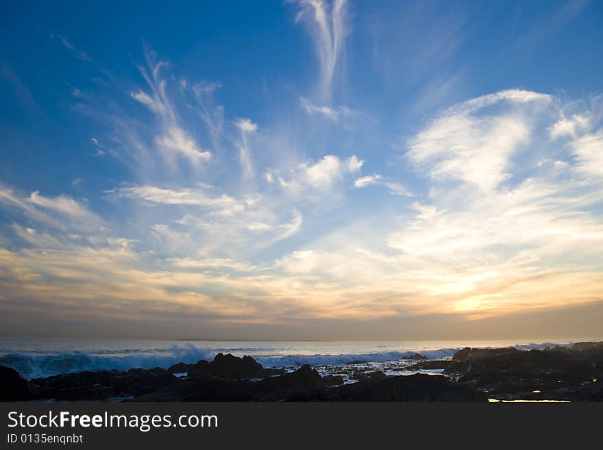 Vivid sunset over the sea with deep blue skies and bright sun spots.