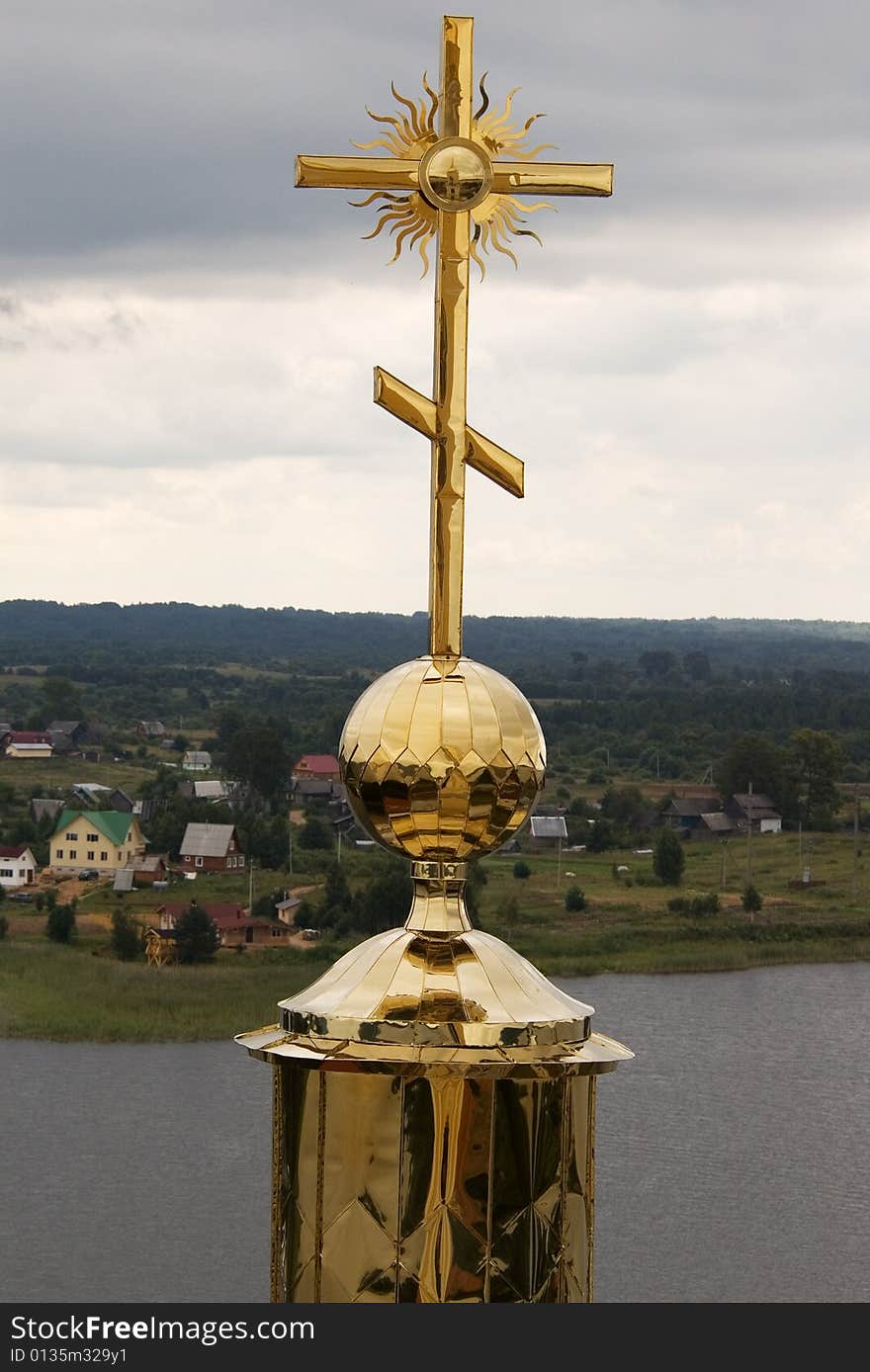 Gold cross with belltower's reflection on orthodox church in a monastery of Nil Stolbenskij, Island Stolbnyj, lake Seliger, near Ostashkov, Russia, view from a belltower