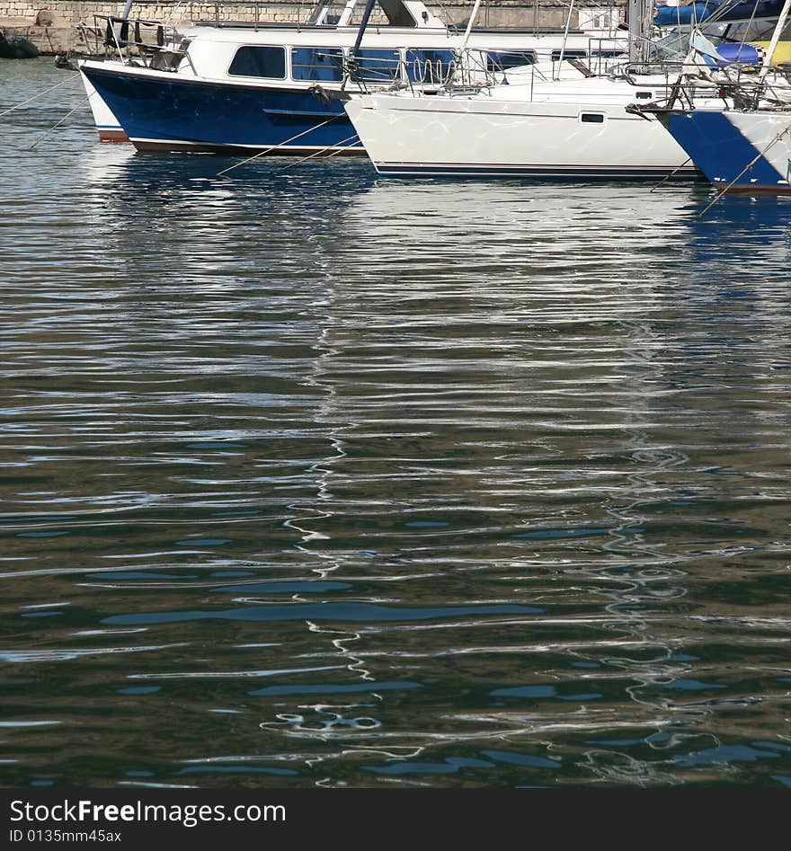 An image of boats and yachts reflecting in water