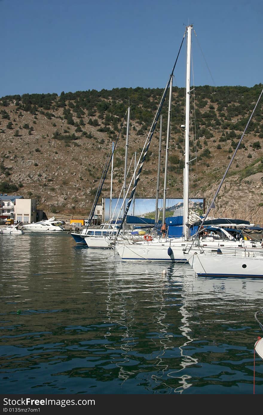 An image of boats and yachts reflecting in water