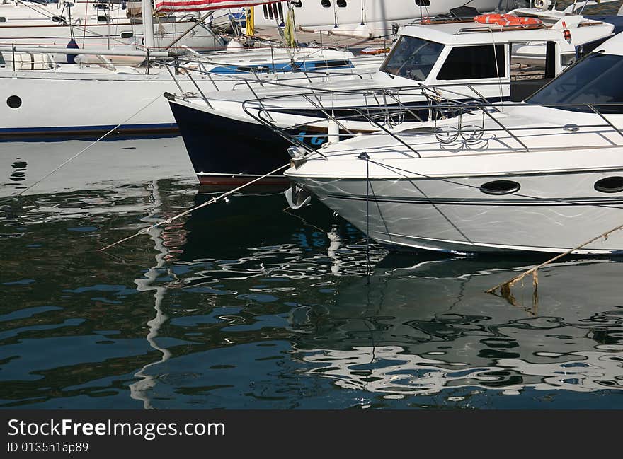 An image of boats and yachts reflecting in water