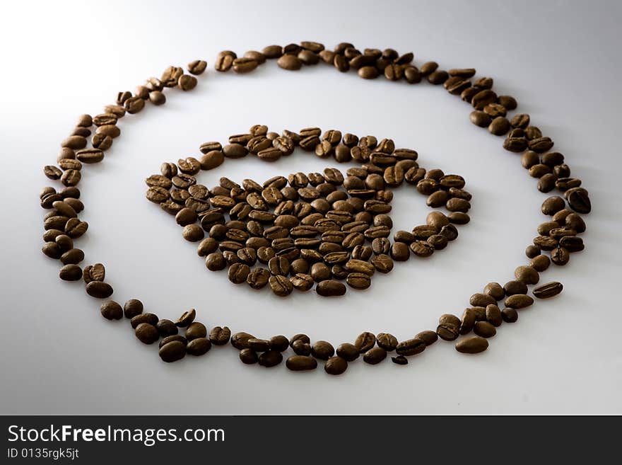 Coffee beans cup shape made with fresh roasted coffee beans light up with spot light and beautiful DOF.